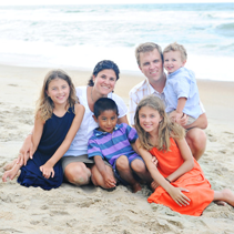 A smiling happy family sitting on the beach.