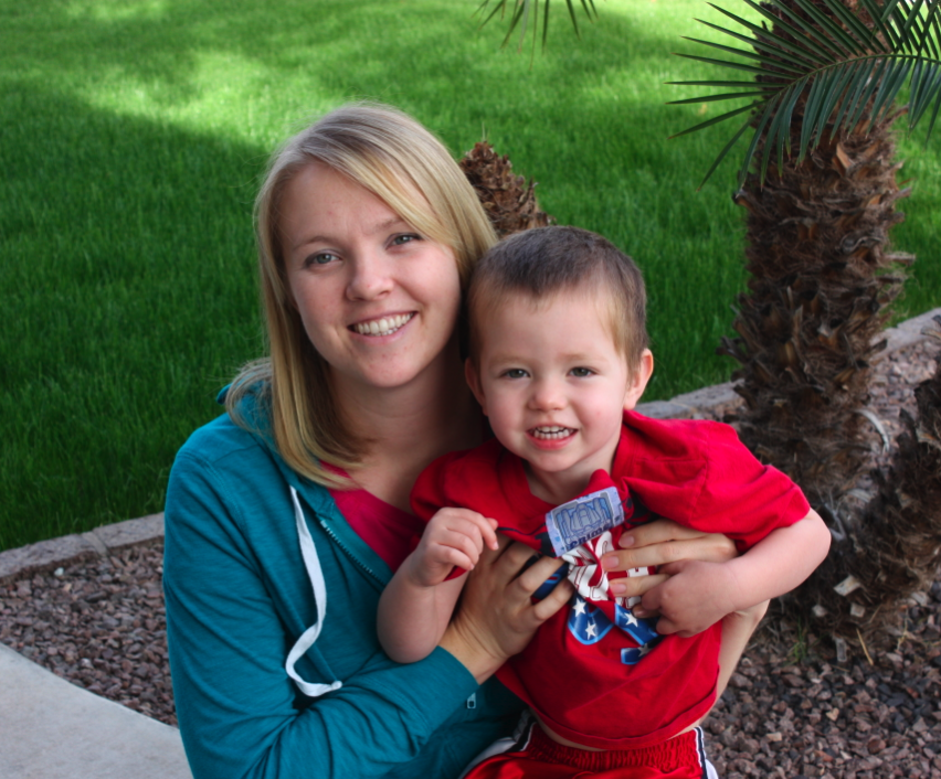 A mother and child next to a palm tree