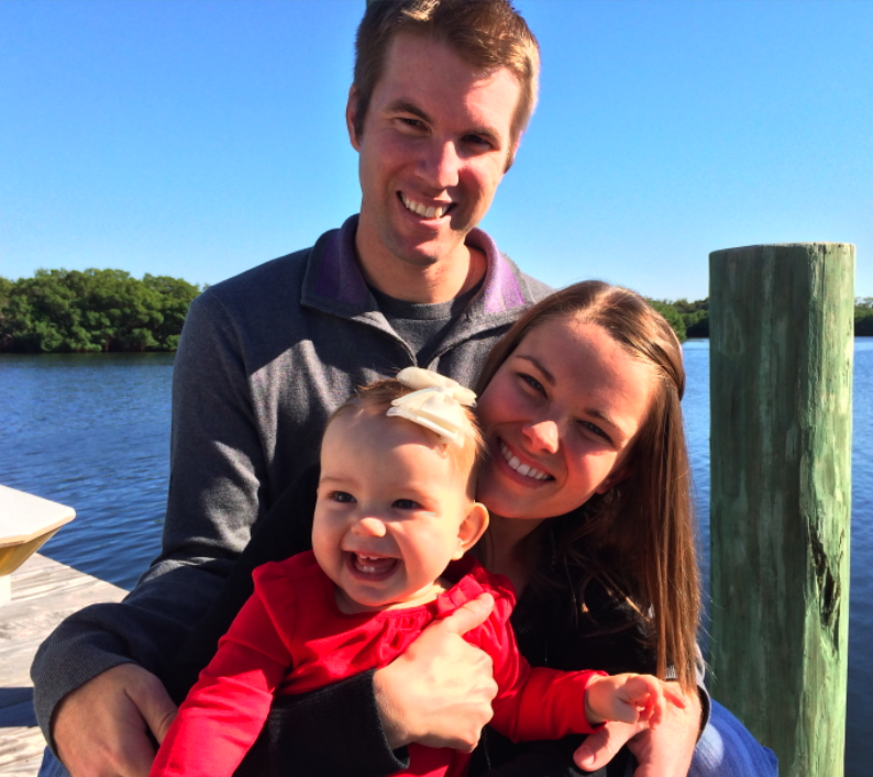 A happy white family sitting on the dock at the lakes