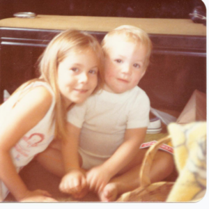 two children look at the camera smiling