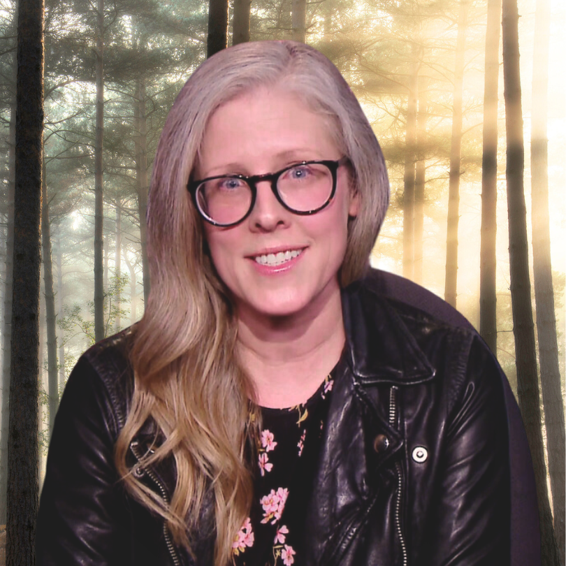 Image of Brandy Zadrozny, a blonde woman with glasses, in front of a bucolic wooded setting