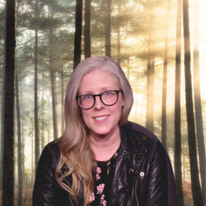 Image Of Brandy Zadrozny, A Blonde Woman With Glasses, In Front Of A Bucolic Wooded Setting