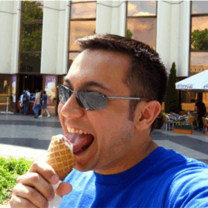 A man licks ice cream out of a waffle cone