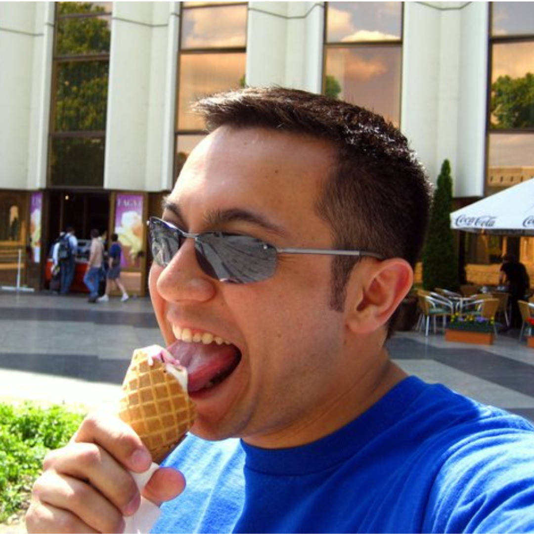 A man licks ice cream out of a waffle cone